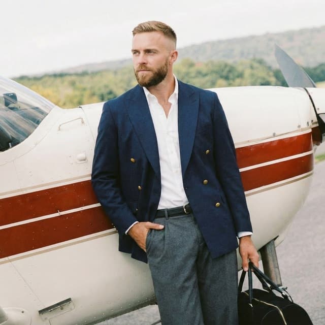 Ethan in a navy blazer next to a private plane