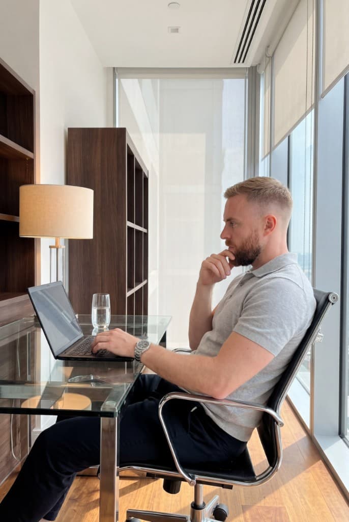 Ethan working at the laptop in a high-rise office